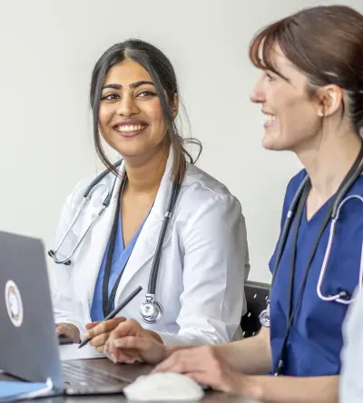 Nurse Practitioner Who Went From RN to MSN Online Smiling with Patient